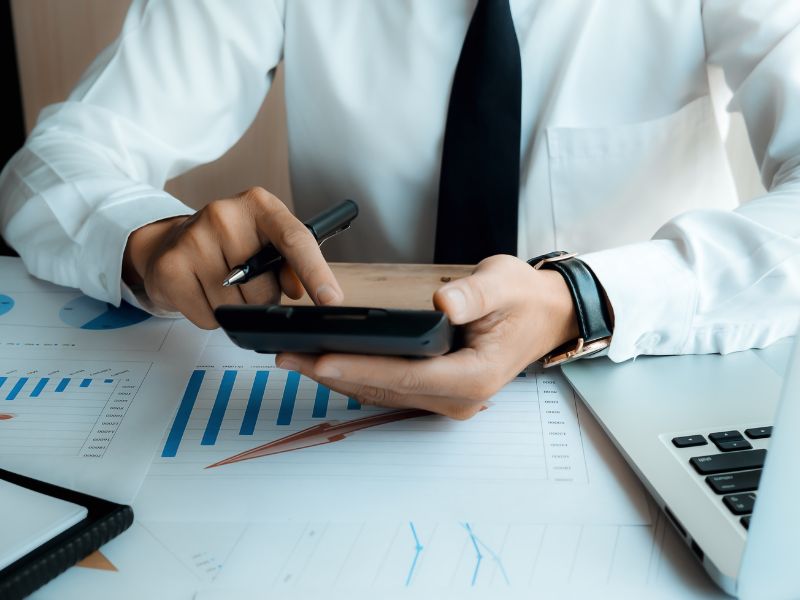 consulente finanziario con calcolatrice analizza i costi aziendali