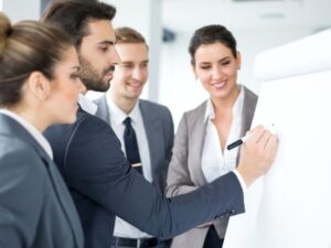 uomo scrive alla lavagna in ufficio durante una sessione di formazione dei dipendenti