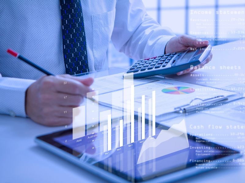 uomo con calcolatrici e grafica che fa vedere dei grafici in rilievo