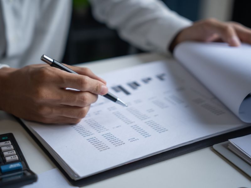 uomo con penna indica dei grafici finanziari