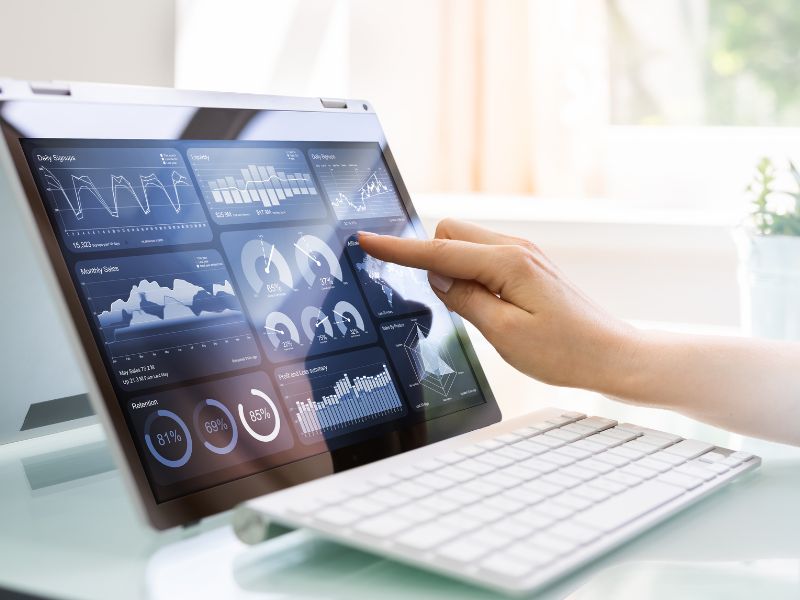 donna indica un grafico finanziario sullo schermo di un computer