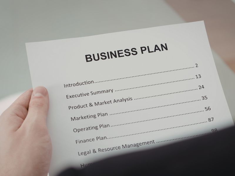 uomo tiene un foglio in mano con scritto business plan