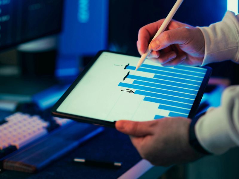 uomo con tablet che indica dei grafici di crescita aziendale