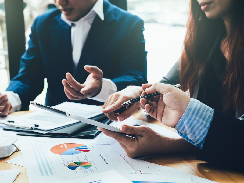 uomo e donna analizzano dei grafici relativi ai rischi aziendali finanziari
