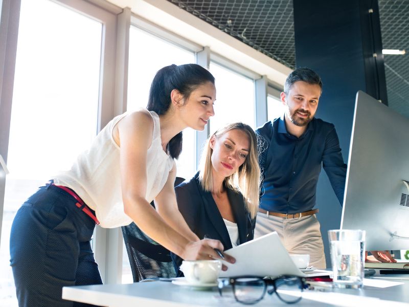 persone in ufficio guardano indicatori finanziari al computer